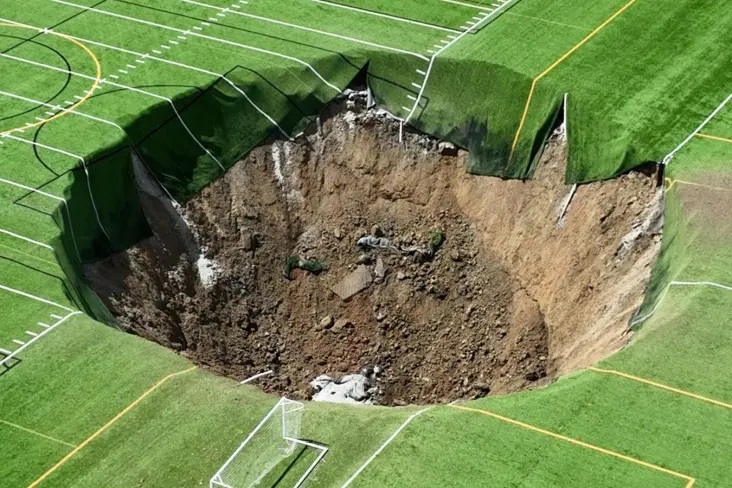 Nos EUA, um campo de futebol cai sob o solo e forma um funil gigante