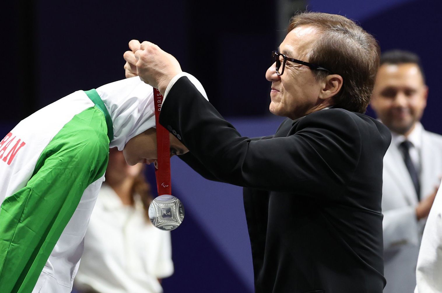 Jackie Chan entregando medalla.